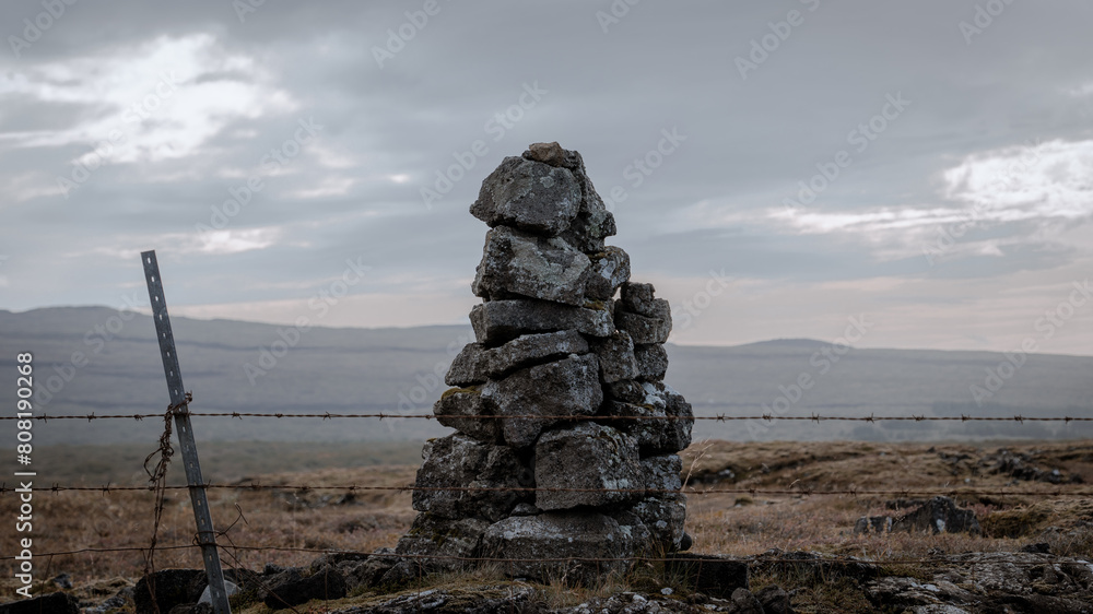 Stack of stones in a field. Pile of huge stones, ancient traditions, signals, Nordic atmosphere, pagan beliefs.