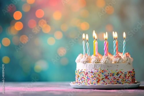 Delicate birthday cake with candles on a blurred bright background. Concept for celebrating children s holidays.   mpty space for text. 