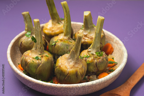  French artichokes à la Barigoule or Carciofi alla provenzal. Provencal artichokes stewed with carrots, onions, white wine, bay leaves and Provençal herbs. Spring recipes from southern France. Lavende photo