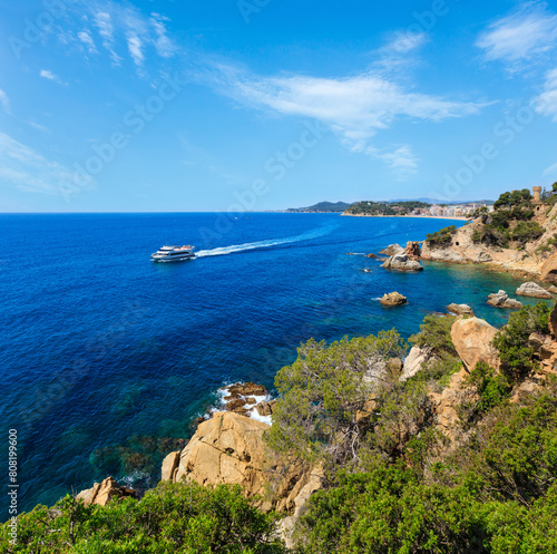 Summer sea rocky coast view with Castle of Sant Joan and boat (Lloret de Mar town, Catalonia, Spain). © wildman