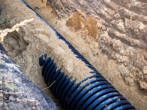 Laying a plastic drainage pipe in a trench