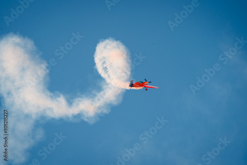 Acrobatic Airplane Performing at Air Show Against Blue Sky photo