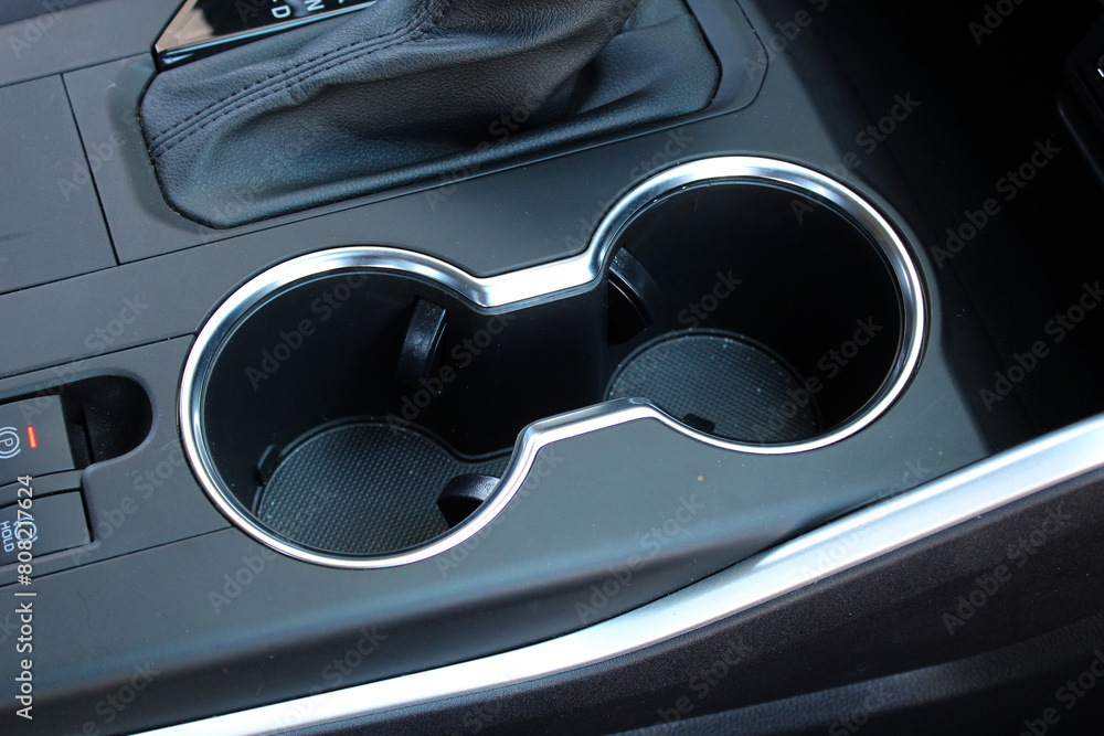 Cup holders in car interior. Closeup car water bottle holder. Car cup holder with heating and cooling mode. Cup holders in car interior. Closeup car water bottle holder. Car cup holder with heating and cooling mode.
