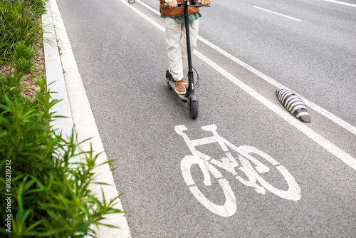 Man riding an electric scooter on designated bike lane photo