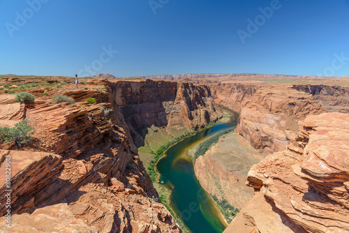 A woman stands on the edge of Horseshoe bend in Page, Arizona, United States. Famous american nature landscape