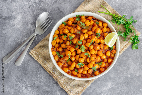 Indian Chickpea Curry with lemon in a Bowl Garnished with Cilantro