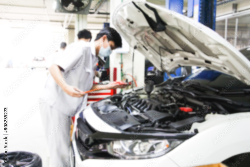 Blurry car repair station and repairman working in the garage. Car maintenance or checking of car repair concept. Blurry car repair station and repairman working in the garage. Car maintenance or checking of car repair concept.