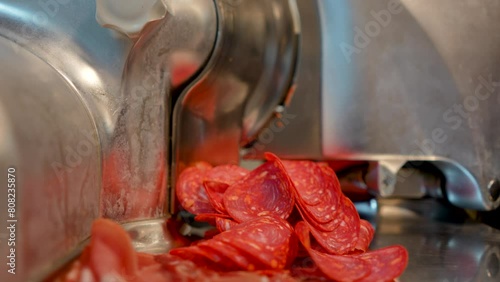 professional slicer cuts pepperoni sausage photo