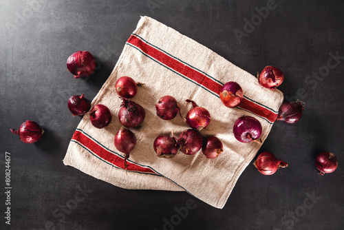 Rote Zwiebeln liegen auf einem Leinentuch in der Küche auf dem Küchentresen