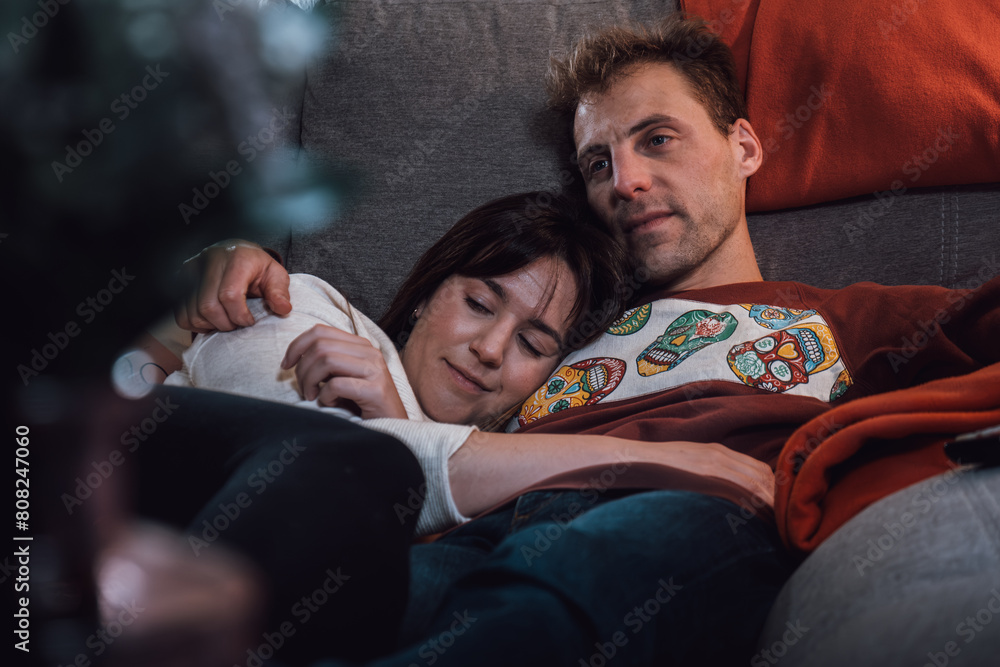 Couple of young adult man and woman lying and hugging while resting on the couch. Real life people at home
Couple of young adult man and woman lying and hugging while resting on the couch. Real life people at home