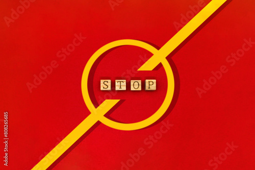 上下に伸びる黄色い停止マークの中心にSTOPの英語ブロックが並ぶ赤い背景 photo