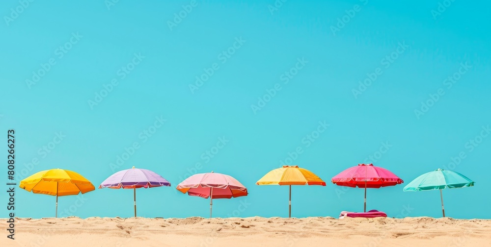 Colorful beach umbrellas lined up on a sandy beach with clear blue skies and bright sunlight. Concept of beach resort, summer vacation, sun protection, and leisure. Banner. Copy space Colorful beach umbrellas lined up on a sandy beach with clear blue skies and bright sunlight. Concept of beach resort, summer vacation, sun protection, and leisure. Banner. Copy space