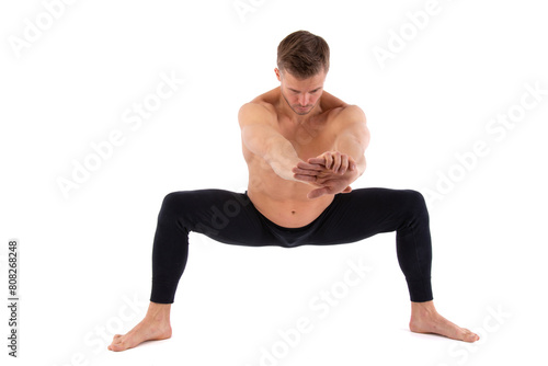 Fitness and meditation. Healthy lifestyle. Young attractive man doing yoga on a white background.