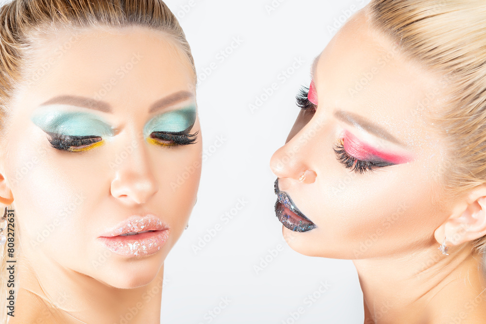 Fashion twins with a bright make-up posing in studio. Beauty, cosmetics ...