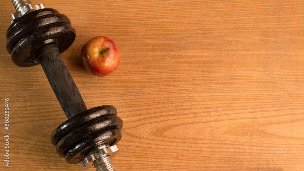 photography of apple and dumbbell on color background, sports background, healthy living, exercise photography of apple and dumbbell on color background, sports background, healthy living, exercise