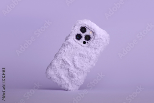 phone in pink fluffy fur peach fuzz color case falls down back view, phone case mockup with three cameras in monochrome colours isolated on background