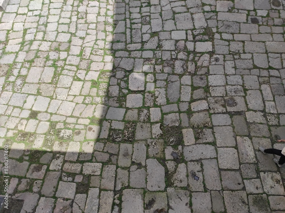 Fototapeta premium Cobblestone texture. Gray paving stones outside close-up. Design blank