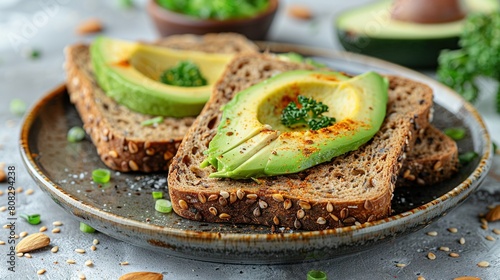  A close-up shot of two sandwiches on a plate, one with avocado on top