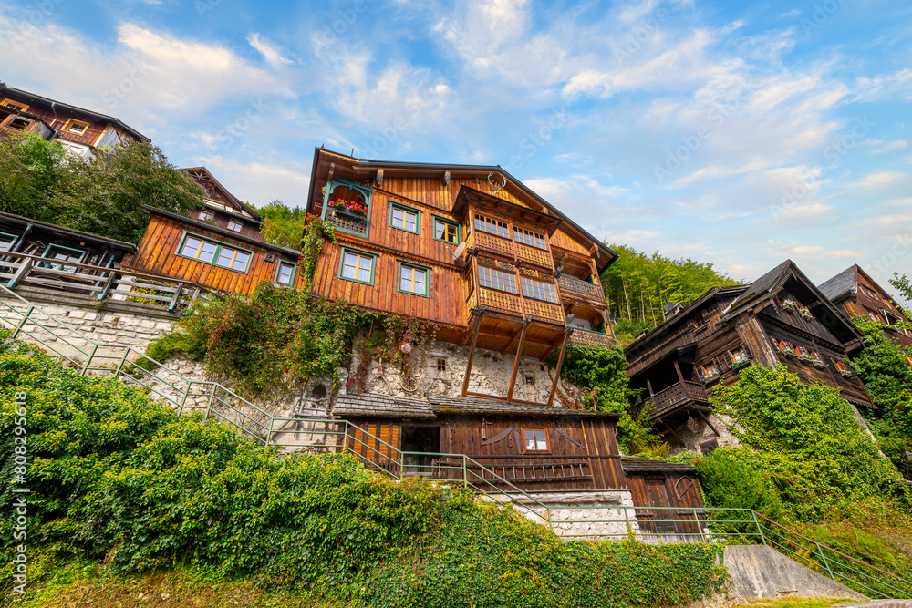 Traditional historic wooden homes built above one another on the steep mountains and cliffs above the lake in Hallstatt, Austria.