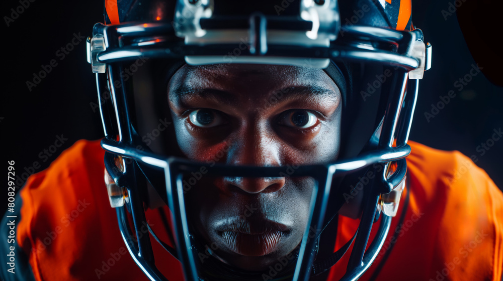 Close-up of a focused american football player wearing a helmet and game attire, showcasing determination and passion against a dark background. Ideal for sports themes and athletic determination Close-up of a focused american football player wearing a helmet and game attire, showcasing determination and passion against a dark background. Ideal for sports themes and athletic determination