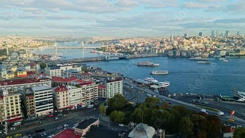 Aerial drone wide angel landscape video of the Galata Bridge or Galata Köprüsü in Eminönü Ferry terminal and the city, Istanbul, Turkey during a sunrise photo
