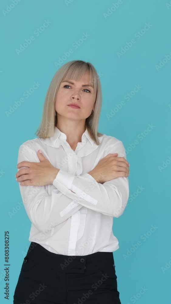 Portrait of a sad Caucasian woman in grief, standing on blue background. Emotional stress, frustration, depression concept. Vertical video. Portrait of a sad Caucasian woman in grief, standing on blue background. Emotional stress, frustration, depression concept. Vertical video.