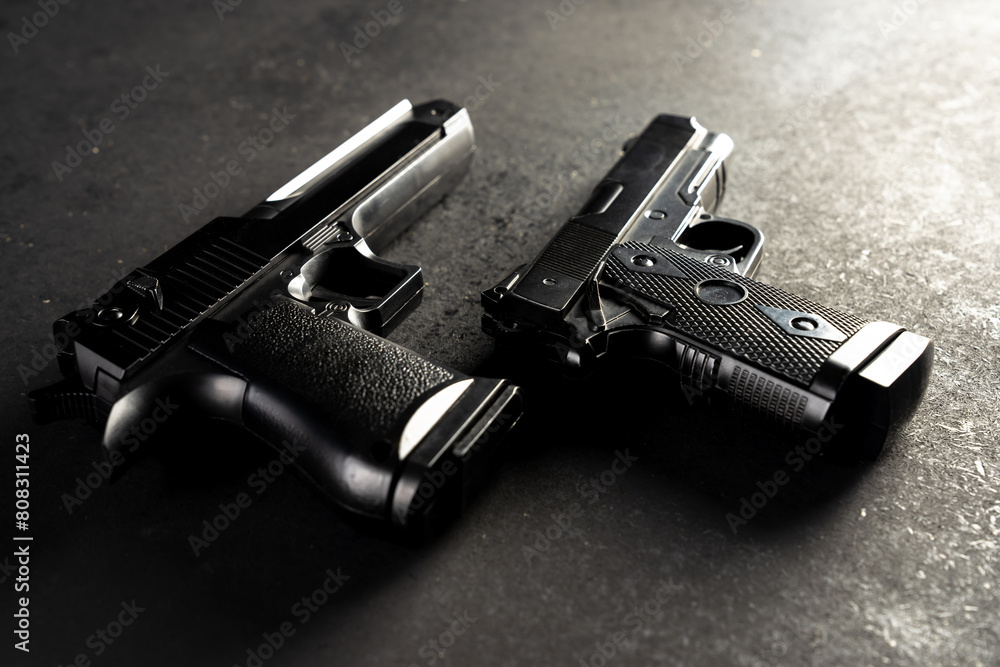 Two guns on black table, criminal concept Two guns on black table, criminal concept