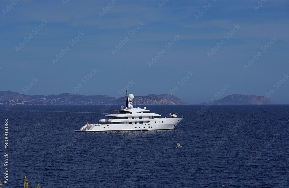 A luxury yacht with a helicopter and a seagull, near the coast of Vouliagmeni in Attica, Greece