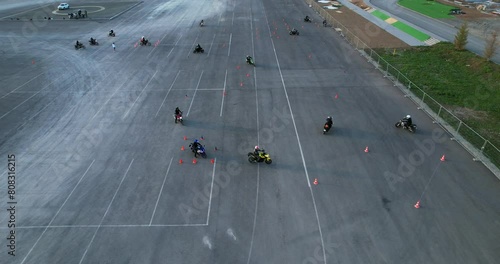 Motorcyclists improve their driving skills on a motorcycle track, aerial view. Riding between traffic cones. Motorcycle school. photo
