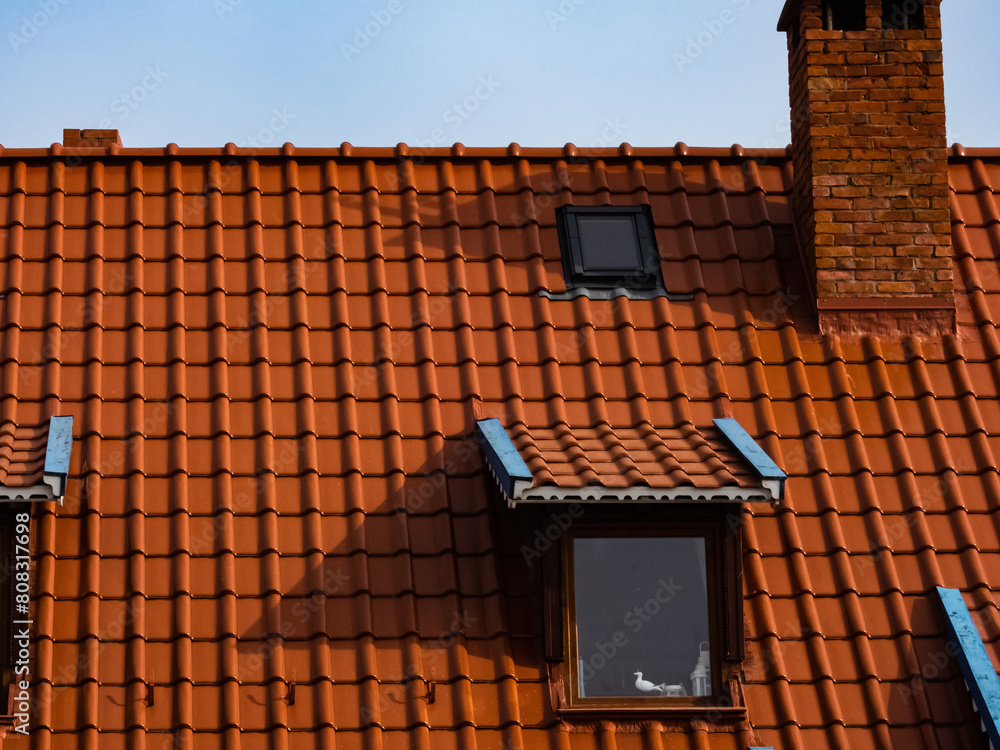 roof of a house made of red tiles with a chimney and attic roof of a house made of red tiles with a chimney and attic
