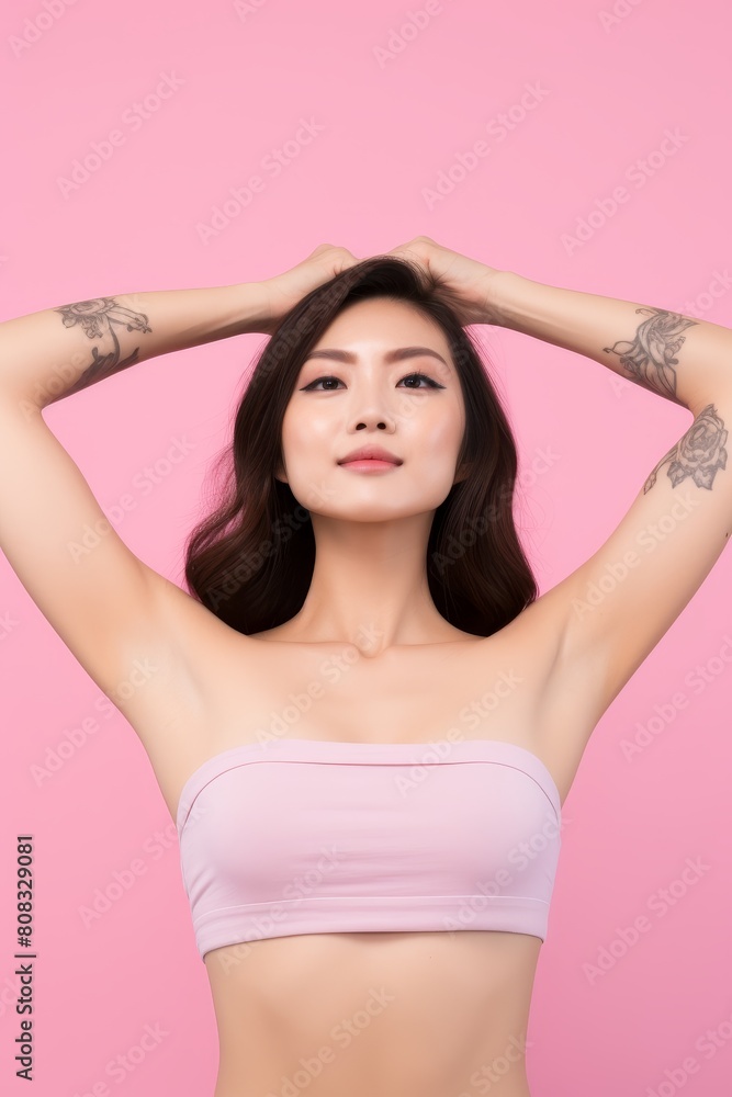confident asian woman with tattoos posing in front of pink background confident asian woman with tattoos posing in front of pink background