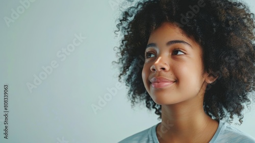 portrait beautiful afro american teenager girl dressed in t-shirt and smiling, light background hyper realistic 