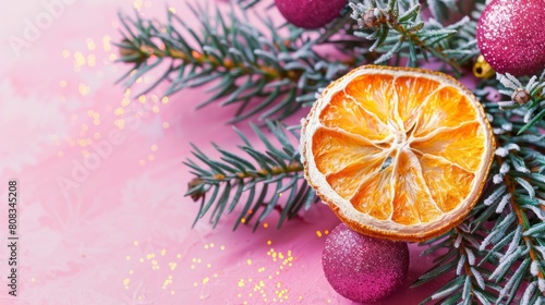 Christmas greeting card with a dried slice of orange on a bright pink background. Homemade decoration. Top view  copy space.