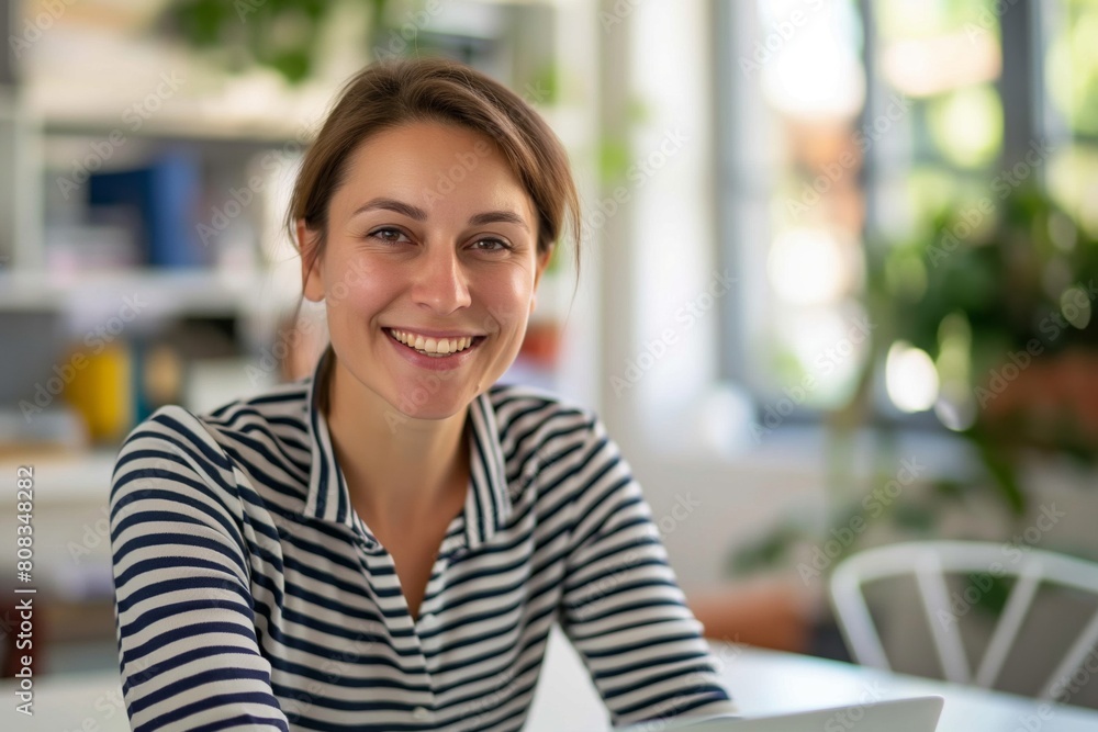 Cheerful young woman with a bright smile poses in a striped shirt, basking in the natural light of a vibrant indoor setting, exuding confidence and positivity Cheerful young woman with a bright smile poses in a striped shirt, basking in the natural light of a vibrant indoor setting, exuding confidence and positivity
