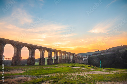Aqueduct between mountains at sunrise with cloudy sky in arcos del sitio in tepotzotlan state of mexico photo