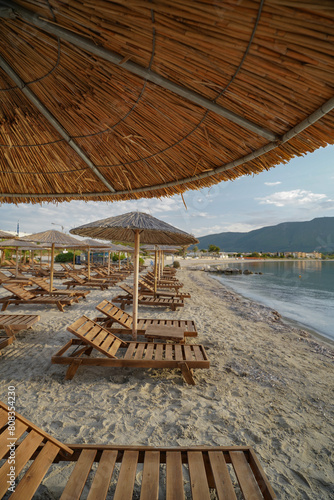 closeup wooden sun beds and parasols on Alikanas beach