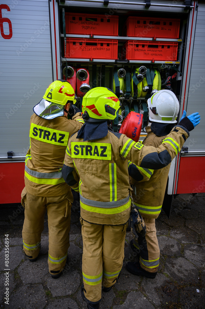 Obraz premium Strażacy przy samochodzie