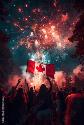 A group of people are celebrating Canada Day with fireworks and a Canadian flag