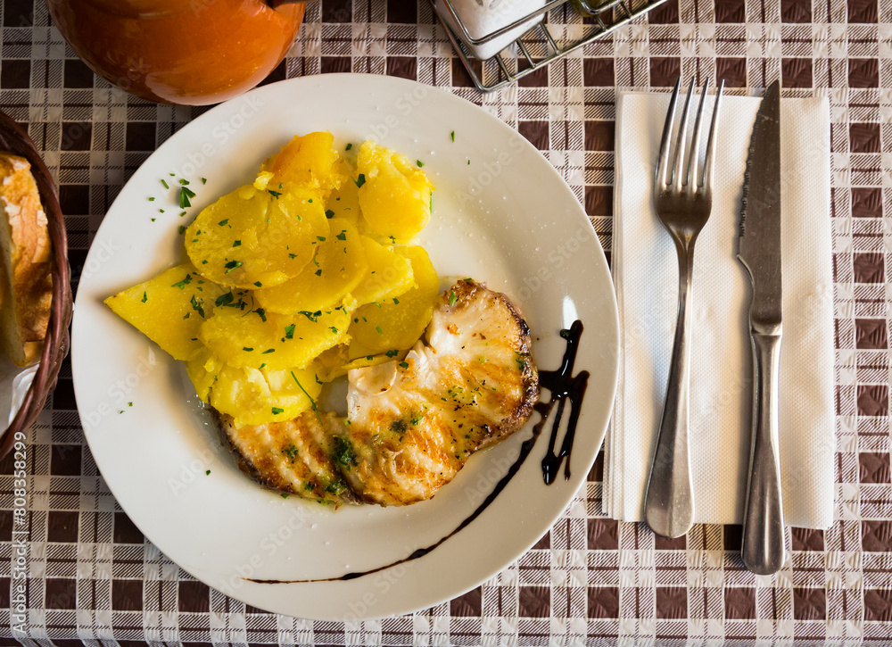 Φωτογραφία Top view of roasted shark steak served with baked potatoes and traditional Spani