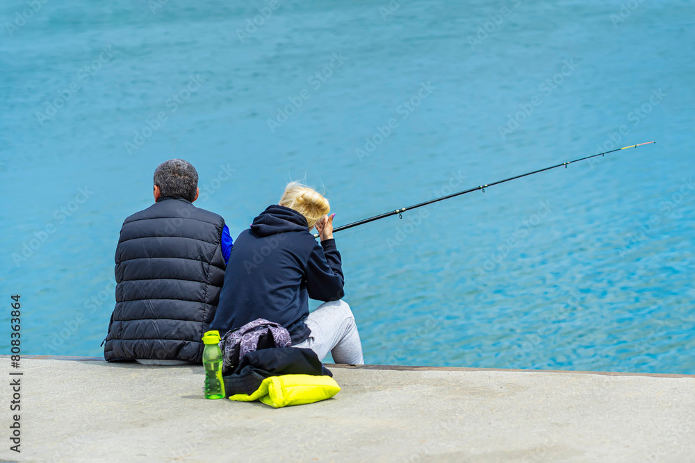 Adult couple is fishing together. Active people and romantic day in nature