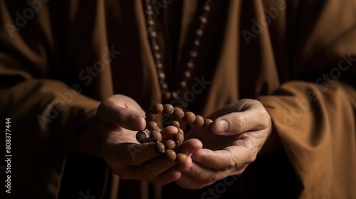 Monk in Brown Robe Holds Wooden Rosary, Symbolizing Peace and Spirituality