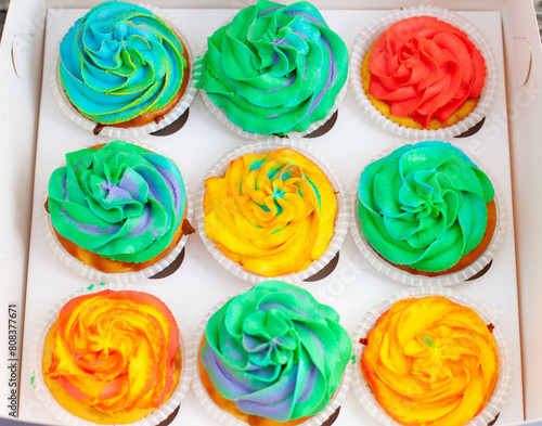 Colorful funny rainbow cupcakes in a gift cardboard box. Idea for a gift