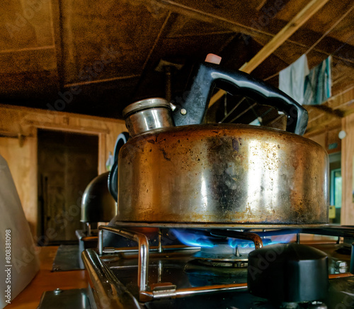 A kettle boiling water on a gas hob. Now we're cooking with gas. photo