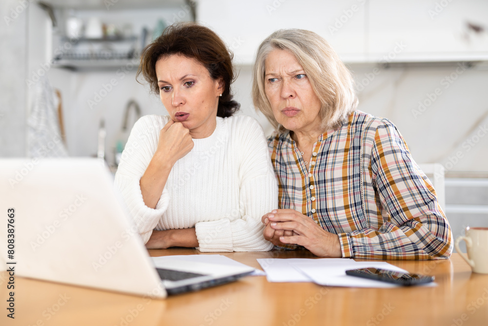 Fototapeta premium Two upset women receive bad news via Internet video call