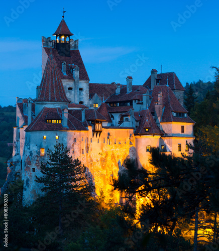 View of main romanian tourist attraction Bran Castle on cliff top in night lights