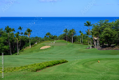 View of the pacific ocean and putting green from the tee box on a tropical golf course, vacation recreation 