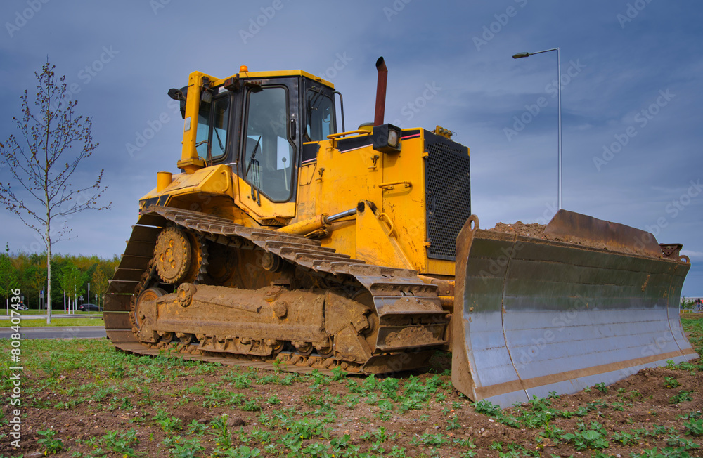 yellow construction bulldozer against the background of the sky and clouds yellow construction bulldozer against the background of the sky and clouds