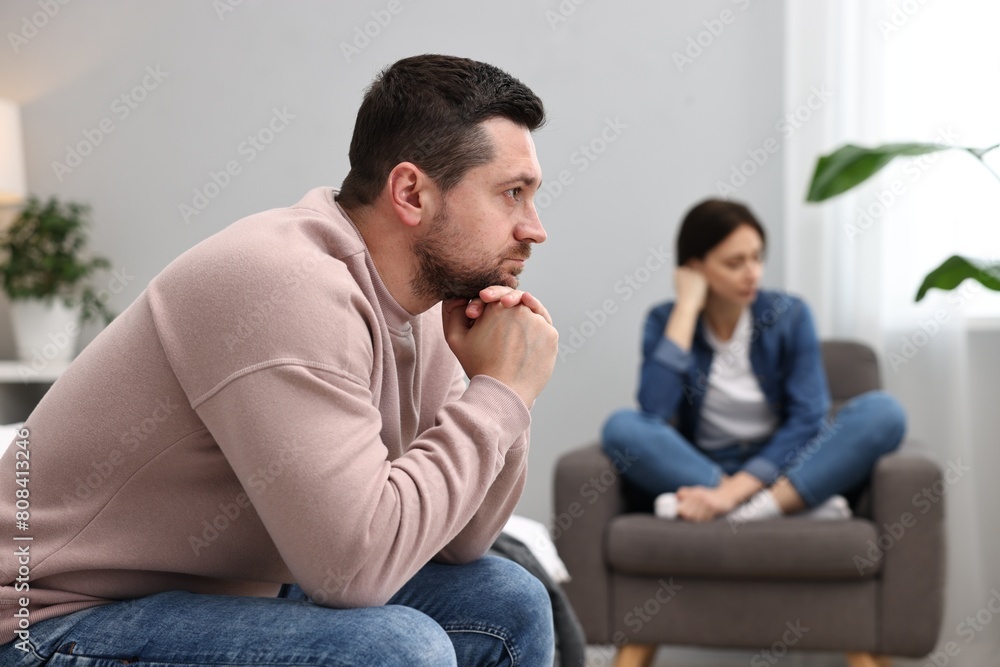 Offended couple ignoring each other after quarrel in bedroom, selective focus. Relationship problems Offended couple ignoring each other after quarrel in bedroom, selective focus. Relationship problems
