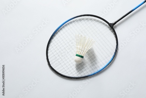 Feather badminton shuttlecock and racket on gray background, top view. Space for text © New Africa