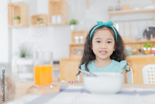 attractive asian children eating meal in the morning, she feeling happy, child nutrition, curly hair children
